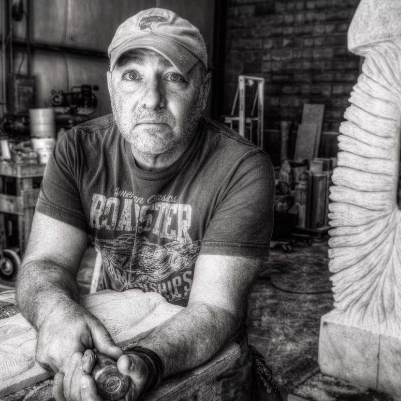 Paris Alexander holds metal sculpting tool in front of sculpture