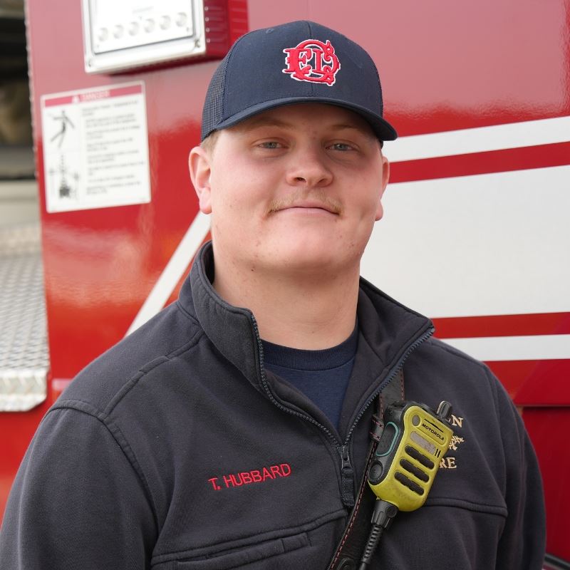 Ty Hubbard Stands in front of fire truck