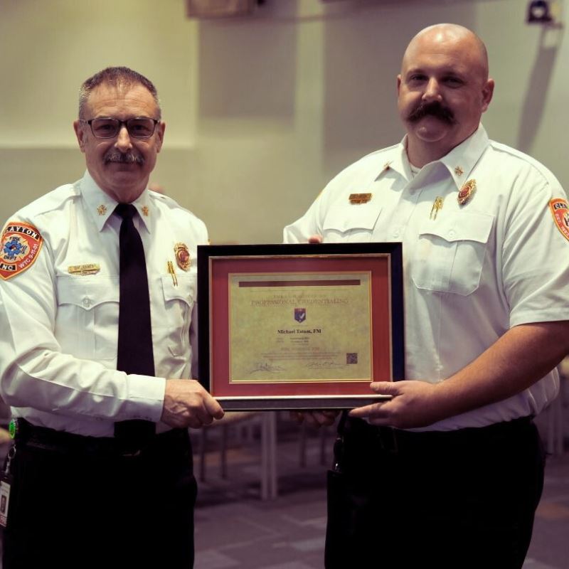 Fire Chief David Ranes hands award to Fire Marshall Michael Tatum