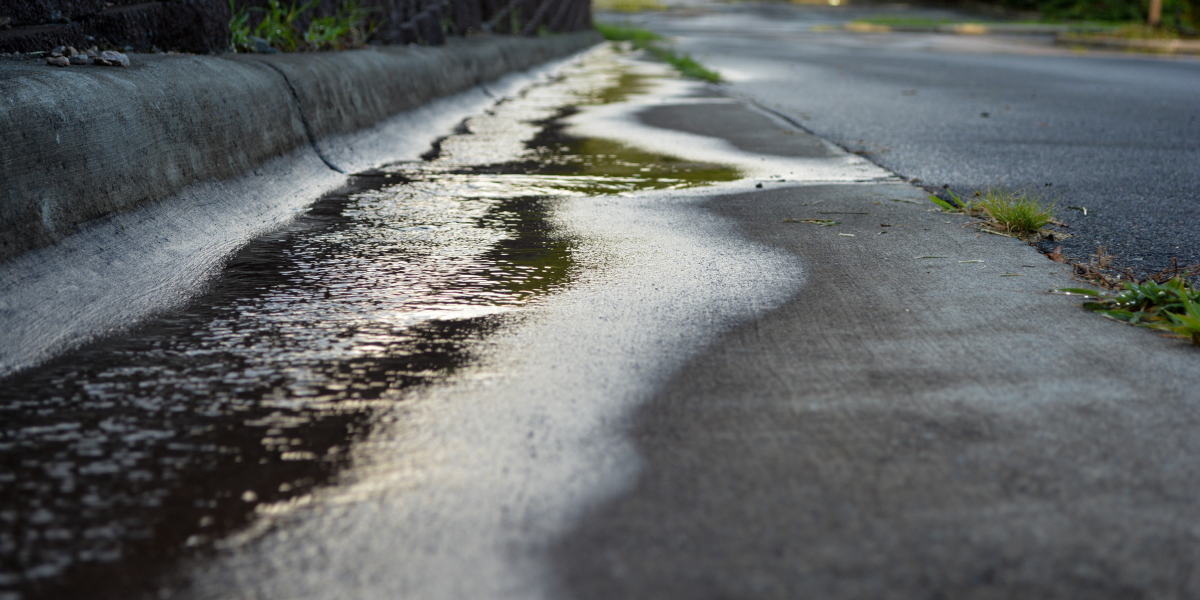 Stormwater running through gutter system on side of road